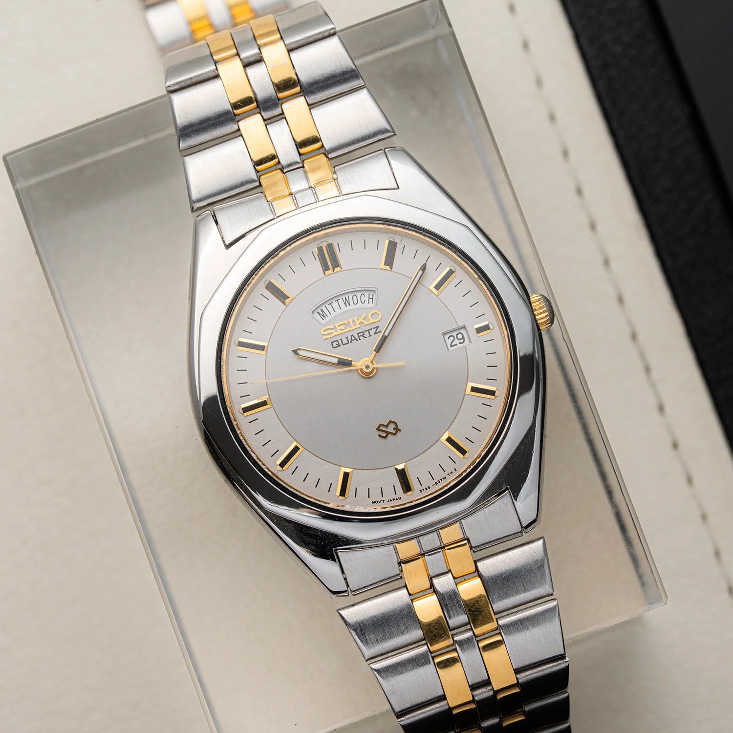 A SSeiko SQ 5Y23-8240 quartz watch with a two-tone silver and gold stainless steel bracelet and a silver dial, presented on a clear display box.
