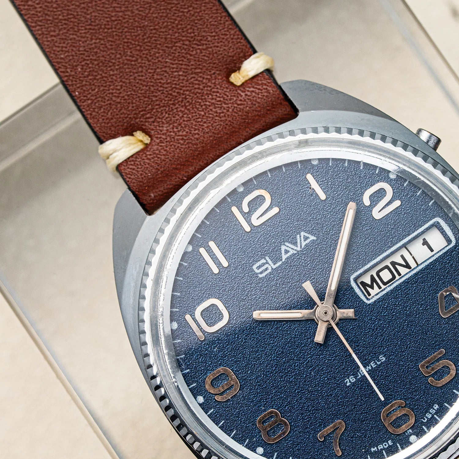 Close-up of a Slava Big Numerals wristwatch with a brown textured leather strap, a blue dial, and a silver-tone case.